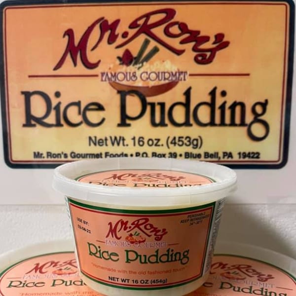 Mr. Ron's Famous Gourmet Rice Pudding containers, with a large sign in the background.