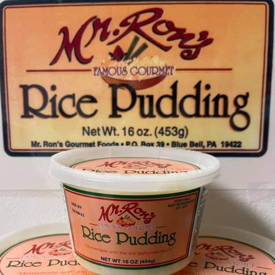 Mr. Ron's Famous Gourmet Rice Pudding containers, with a large sign in the background.