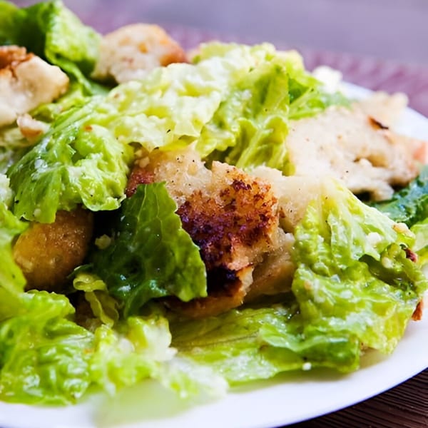 Close-up of a fresh Caesar salad from Ana's Corner Store, featuring crisp romaine lettuce and golden croutons.