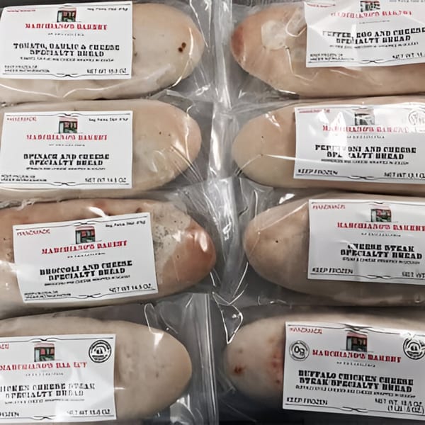 Various Marchiano's Bakery specialty breads, including tomato, garlic, cheese, and pepperoni, wrapped in plastic.
