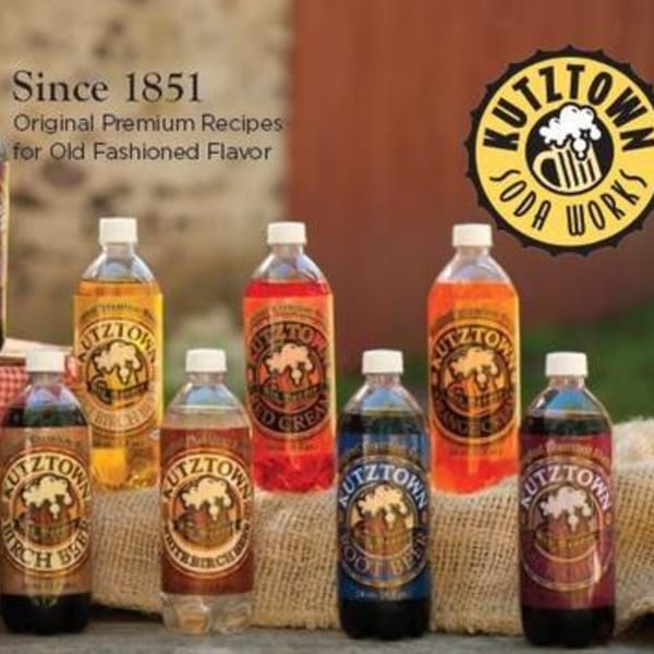 Seven bottles of Kutztown Soda Works beverages in various flavors, including Birch Beer and Root Beer.