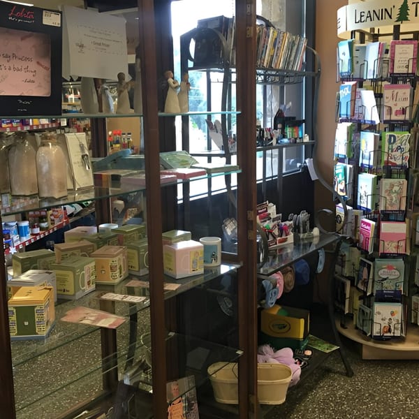 A cluttered corner of Ana's Corner Store, featuring shelves with various retail items and greeting cards.