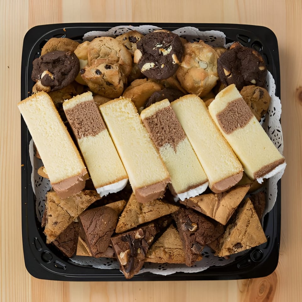 A black tray filled with assorted cookies, brownies, and cheesecake bars from Ana's Corner Store.