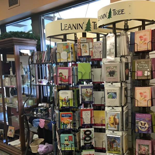 A display of colorful greeting cards from "Leanin' Tree" in a deli setting.