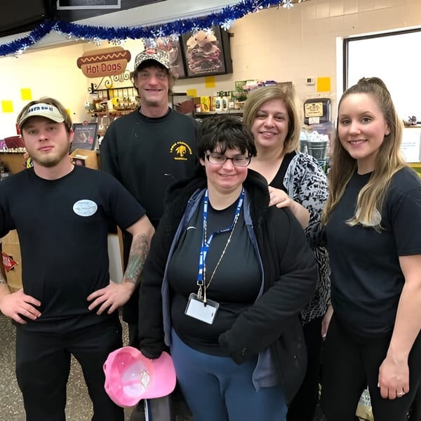 Five Ana's Corner Store deli employees, three men and two women, smiling for a group photo.